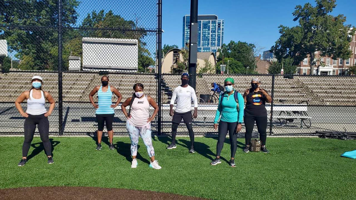 Five women and a coach in front of bleachers
