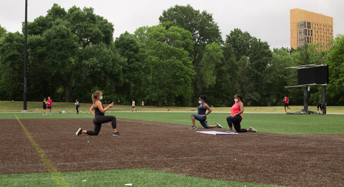 Three people doing lunges on the field