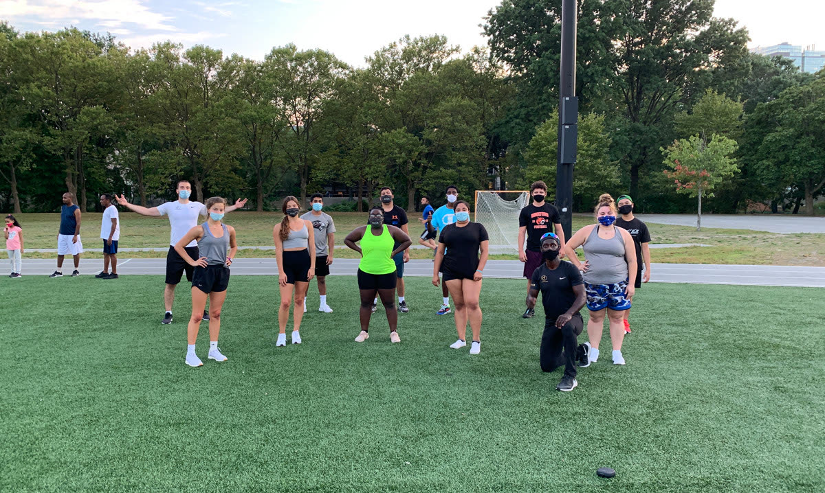 Large group posing on the field at dusk